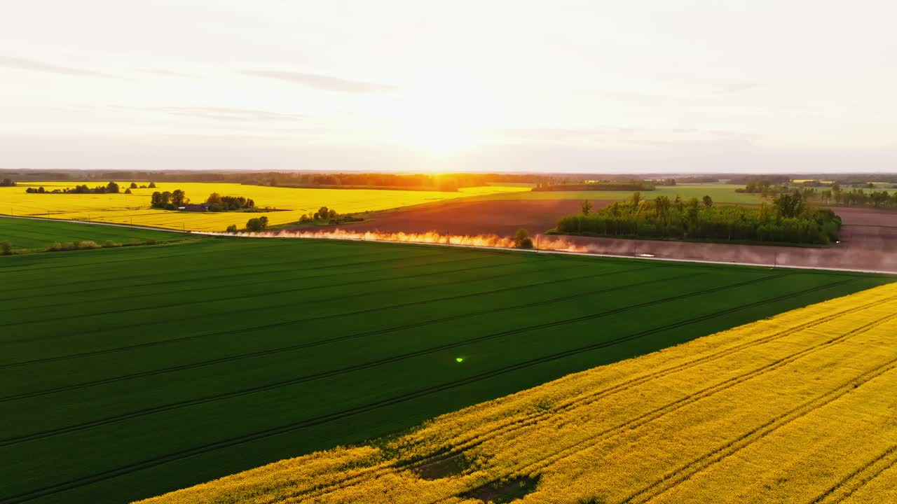 Static aerial frame shows dust clouds glowing as sunlight meets rural motion