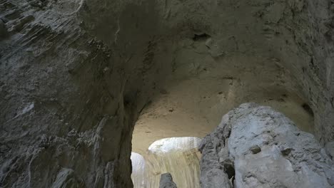 Toma-De-Drone-Con-Pedestal-Dentro-De-Una-De-Las-Cámaras-De-La-Cueva-De-Prohodna,-Que-Muestra-Los-Dos-Agujeros-Más-Comúnmente-Conocidos-Como-Ojos-De-Dios,-Ubicados-En-Karlukovo,-Bulgaria.