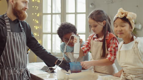 Little-Girl-Using-Hand-Blender-during-Culinary-Class