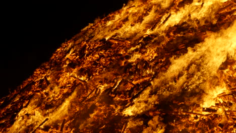 a huge bonfire burns furiously, with lots of embers, on guy fawkes night, the 5th of november in cinema 4k