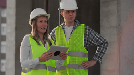 engineers or architects have a discussion at construction site looking through the plan of construction. contre jour. engineers or architects have a discussion