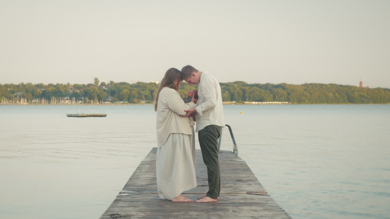Tender family moment on lakeside pier at sunset