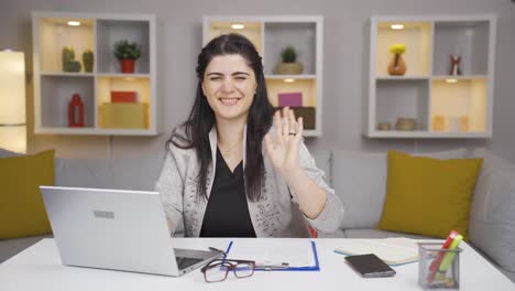 Home-office-worker-woman-waving-at-camera.