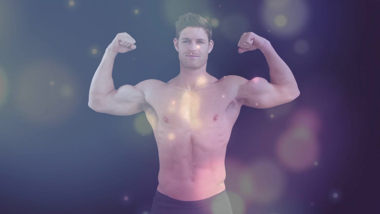 Męski model fitness napinający bicepsy podczas obracania się, uruchamiająca się kamera, światła bokeh pokazujące mięśnie.