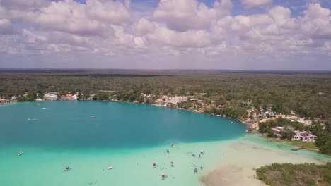 toma panorámica ascendente con drones de la impresionante vista de la laguna de siete colores en bacalar, méxico