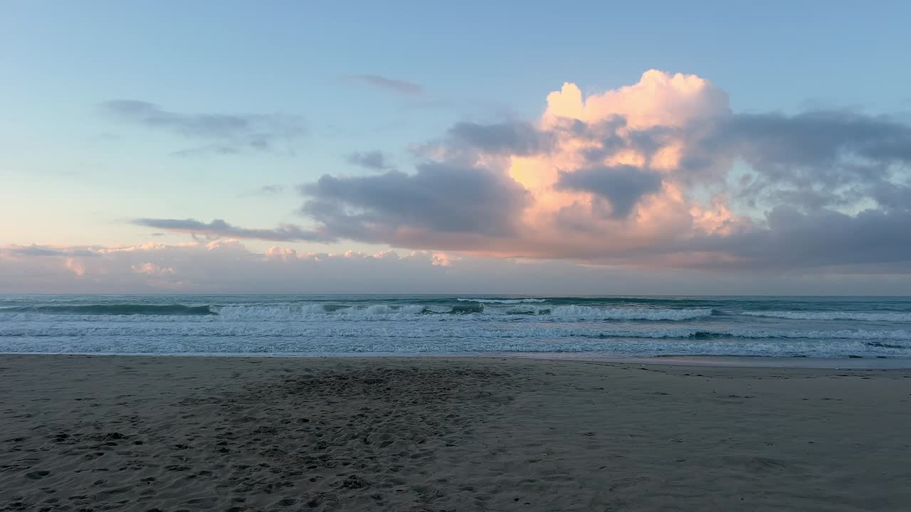 Static front view of the sea at sunset on the beach. Daylight