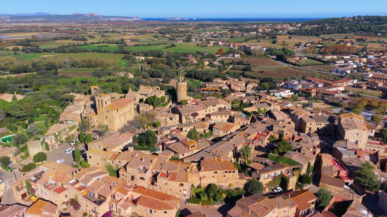 Stunning aerial footage revealing the historic medieval town of pals in costa brava, spain, showcasing its stone architecture, ancient church, and the picturesque mediterranean landscape
