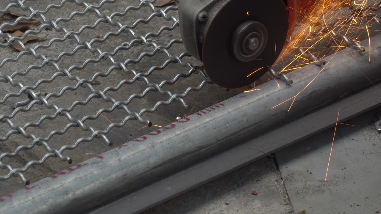 남자는 새 동굴을 만들기 위해 커버 가드 없이 글 그린더를 사용하여 금속 그물을 자르고 있습니다.