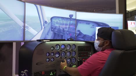 view from behind of a man wearing mask and playin in a flight simulator cockpit