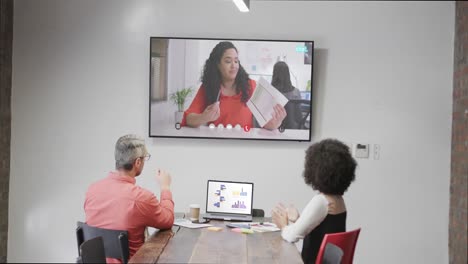 Diverse-business-people-on-video-call-with-biracial-female-colleague-on-screen