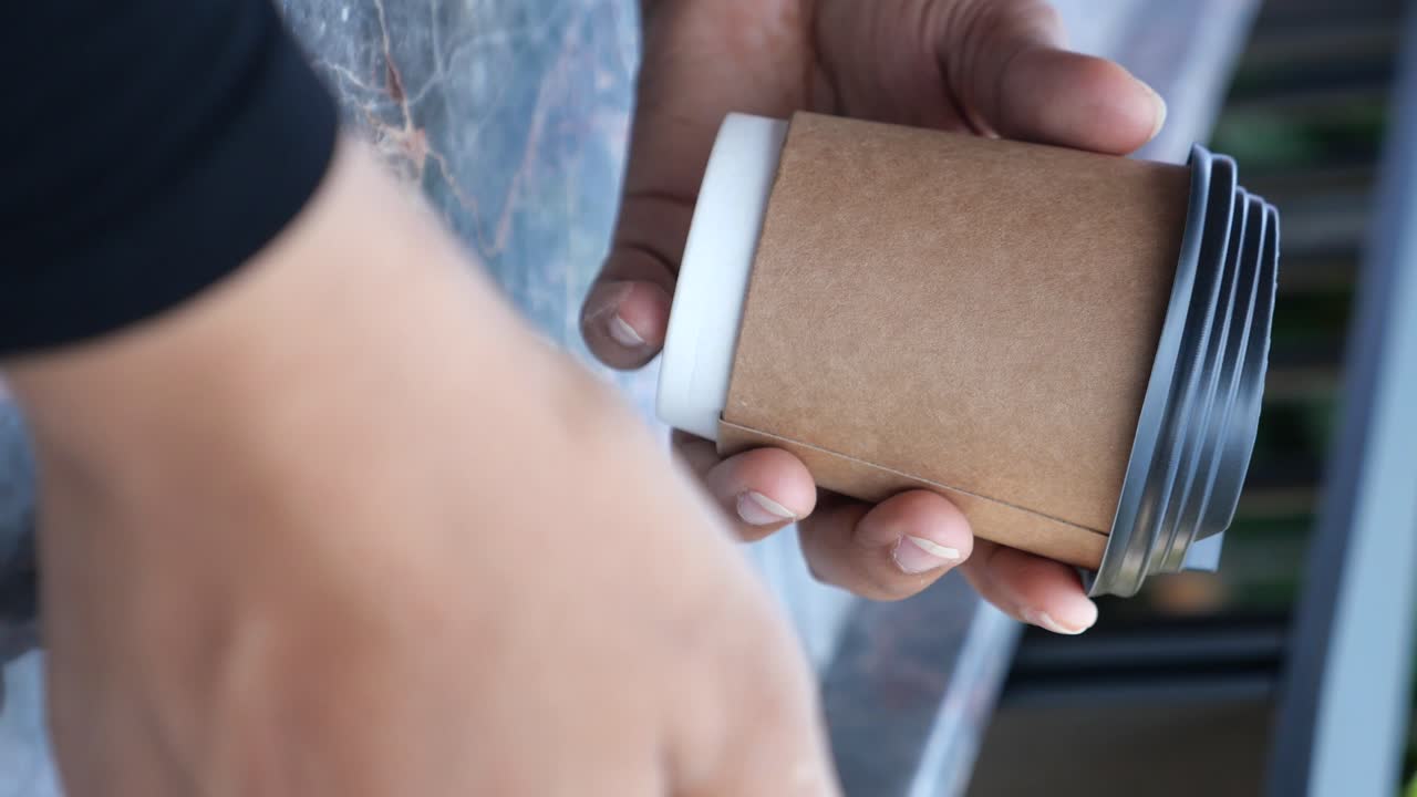 Close-up of hands holding a coffee cup
