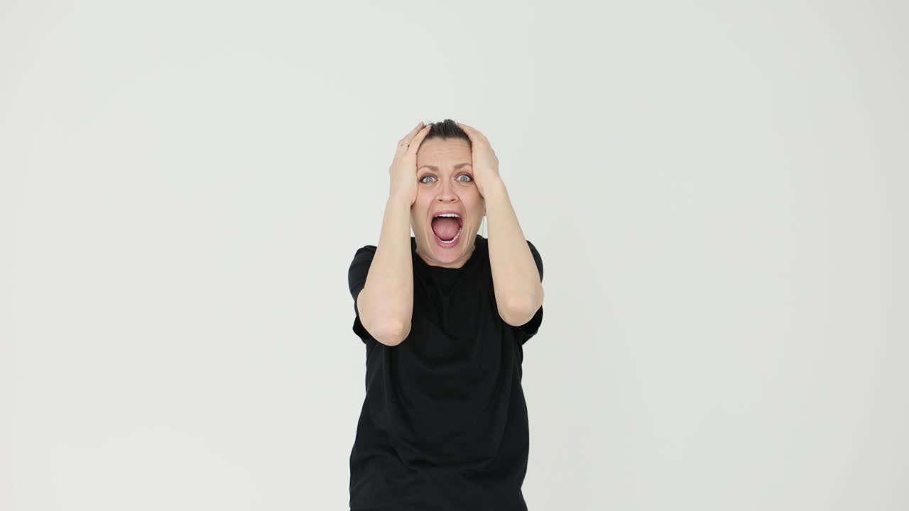 Woman screaming in shock with hands on head