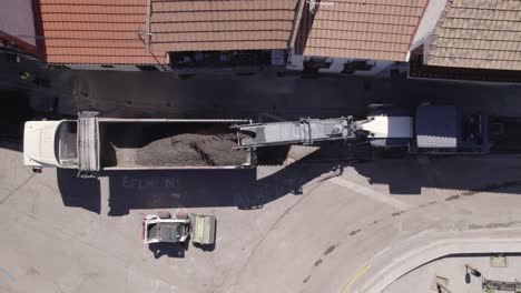 aerial topdown of conveyor belt loading dirt onto truck flatbed