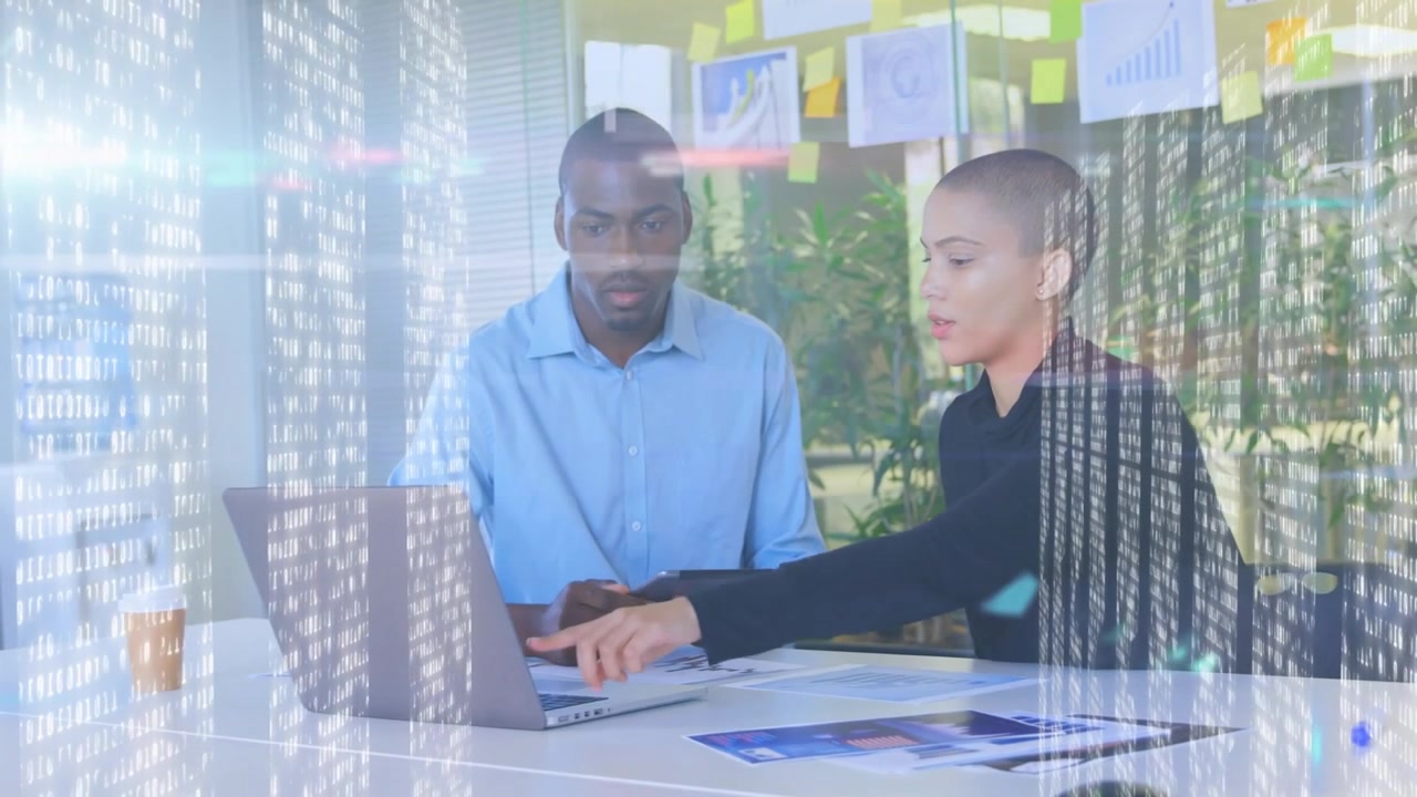 Pointing woman guiding man in light-blue shirt, reviewing laptop and charts at office, overlay