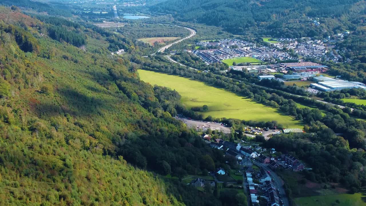 Drone View Over Resolven Valleys Village with Factory Industrial Buildings and Residential Houses with Busy Dual Carriageway Road Winding Through