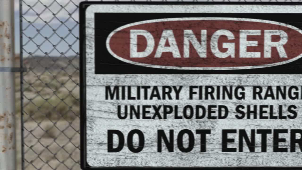 High quality 3D CGI render of a chainlink fence at a high security installation in a desert scene, with a Danger Military Firing Range sign