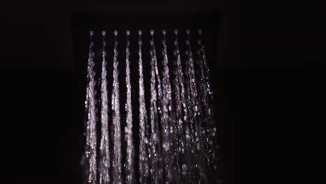 Water-flows-from-a-black-square-nozzle-in-the-shower.