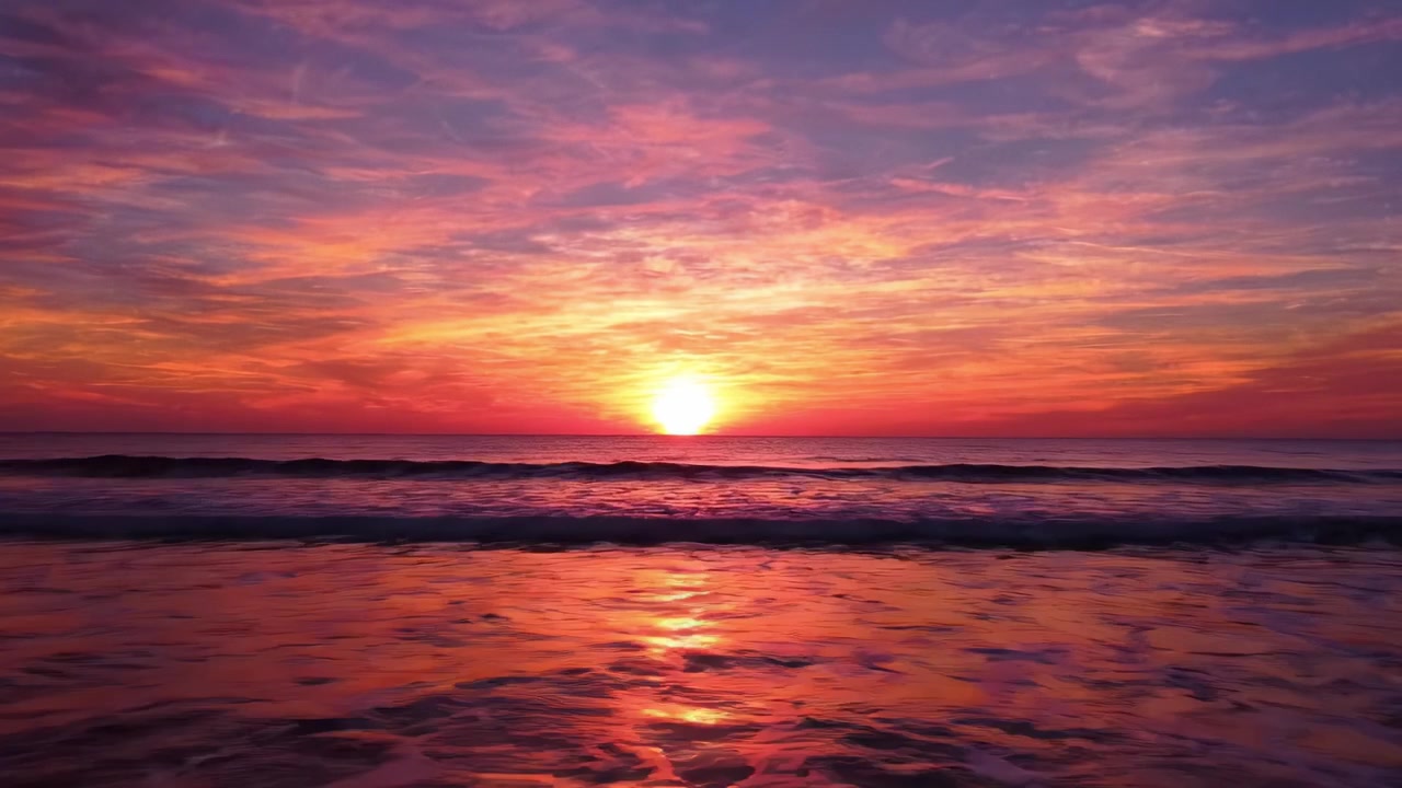 Vibrant Sunset Over Calm Ocean Waters: A Beautiful Display of Colorful Skies and Serene Waves at Dusk