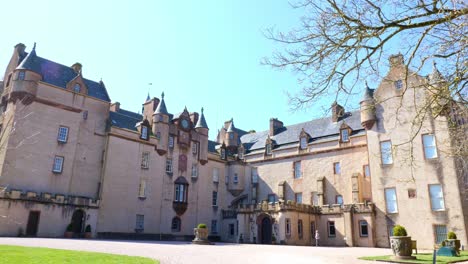 Vista-Trasera-Del-Castillo-De-Fyvie-Con-Una-Dama-Cruzando-El-Patio