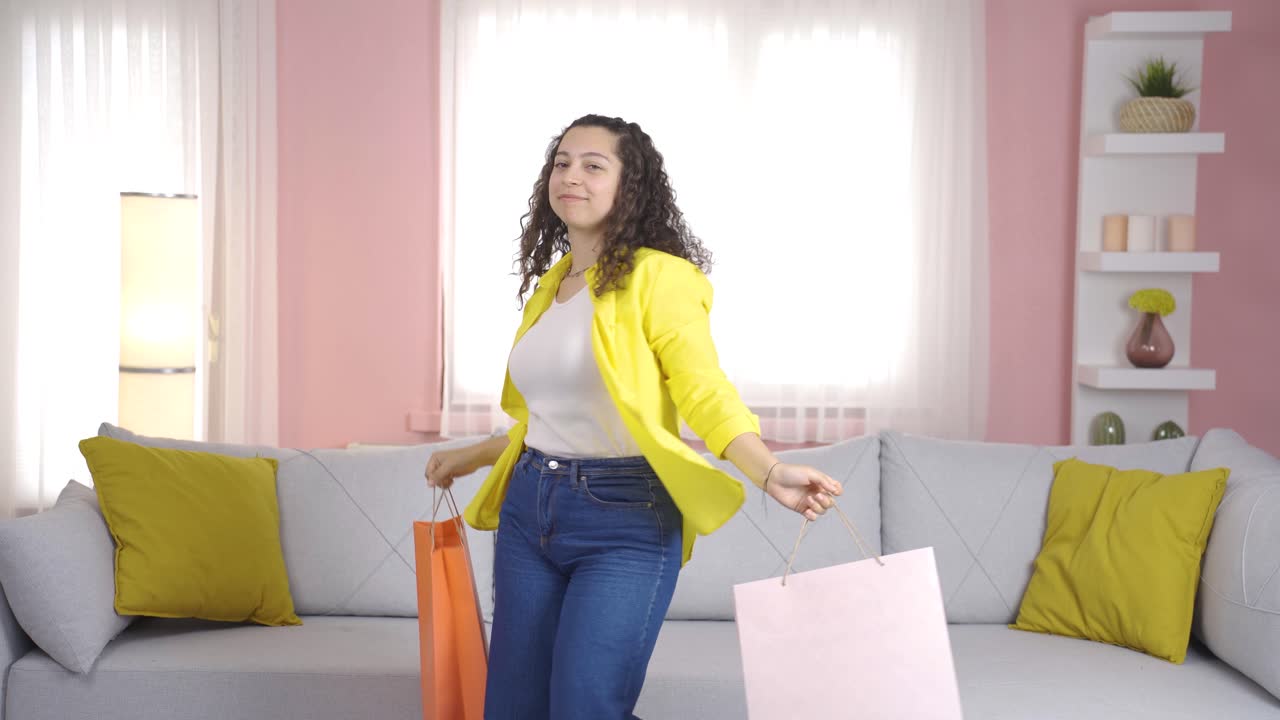 mujer joven bailando con bolsas de compras.
