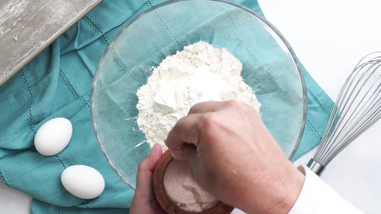 Making a dessert called Red Raspberry Tea Cake made with fresh berries and vanilla buttercream frosting. Great for Tea Parties. Adding salt into the mixing bowl and combining the ingredients