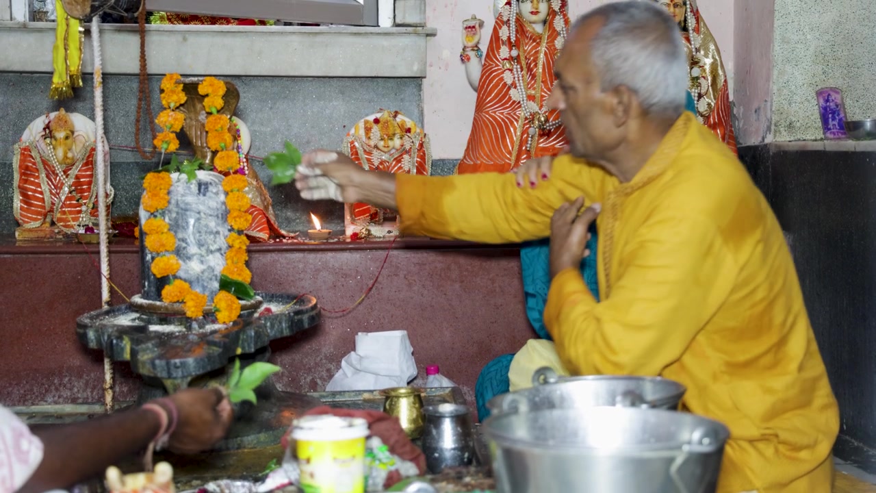 Devoto indù che offre Belpatra (foglie di Bilva) al Signore Shiva durante il culto di Shiva a Shivaratri
