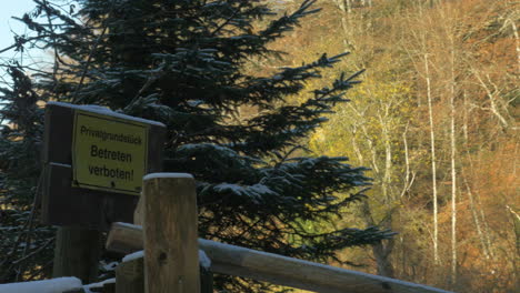 Pan-shot-of-a-yellow-sign-prohibiting-trespassing-in-Germany