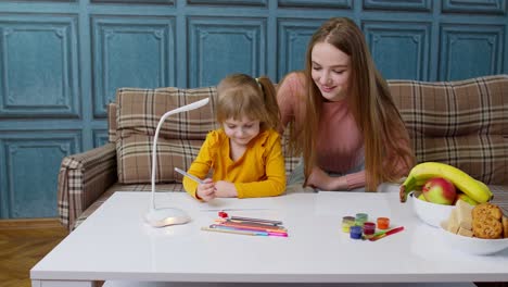 Linda-Hija-Pequeña-Aprendiendo-A-Escribir-Tareas-Con-Una-Madre-Joven,-Educación-A-Distancia-En-Casa