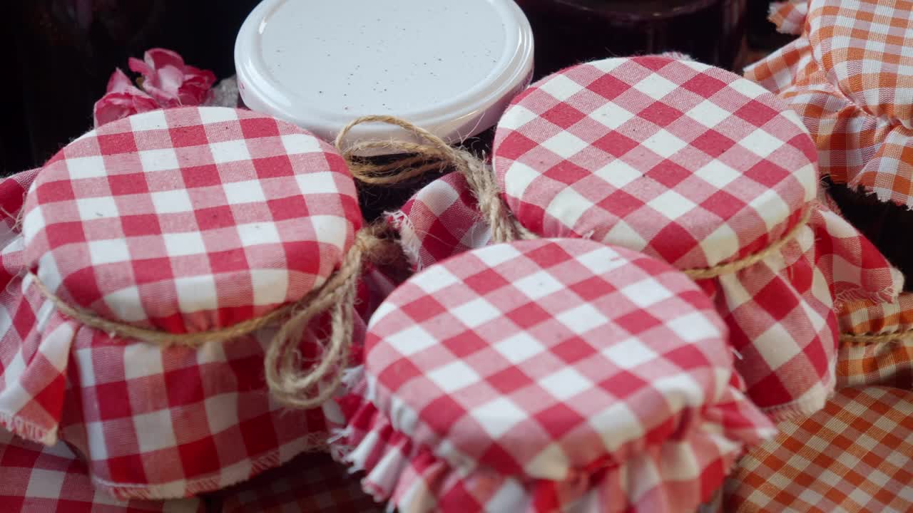 Close up of jars of homemade jam with gingham fabric tops