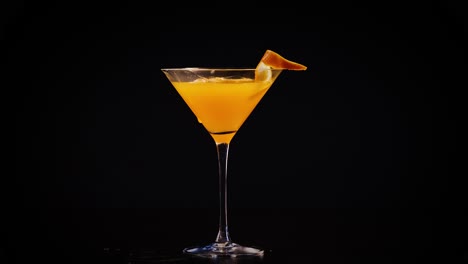 orange juice being poured into a cocktail glass