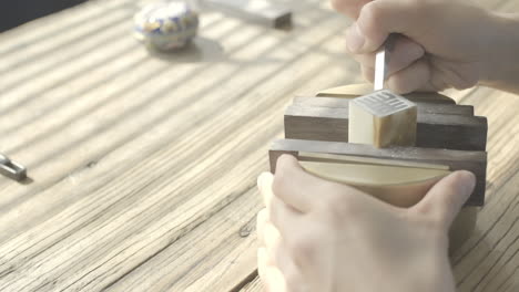 close up shot of artist carving a chinese name chop seal stamp