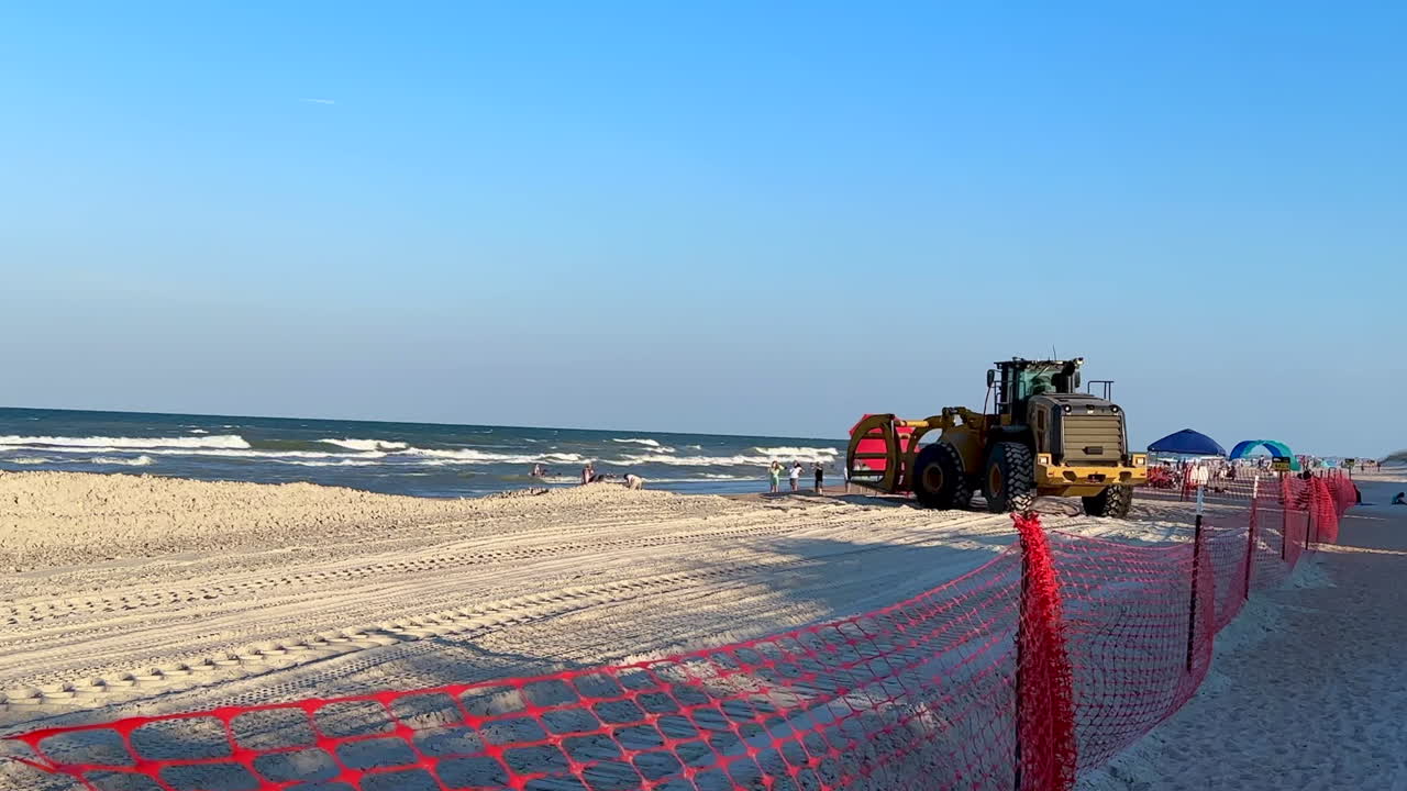 Pipe loader construction equipment driving by, beach replenishment