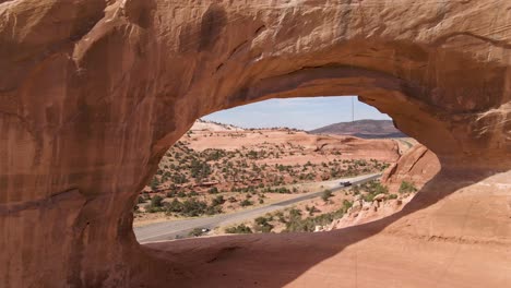 Utah---Wilson-Arch-Cerca-De-La-Hermosa-Roca-Roja-Moab,-Drone-Aéreo-épico-Volando-A-Través-Del-Arco