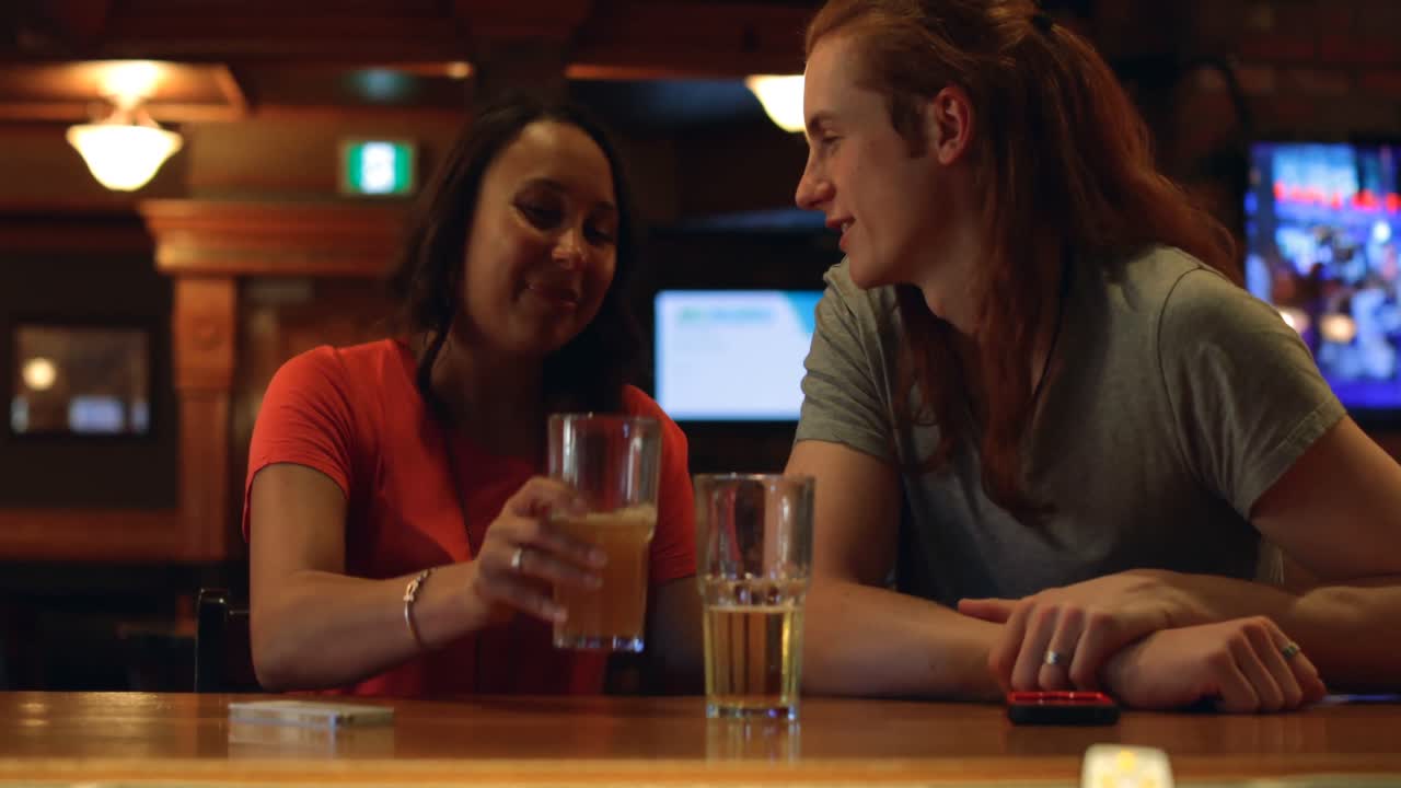 coppia che beve birra al bancone del bar 4k