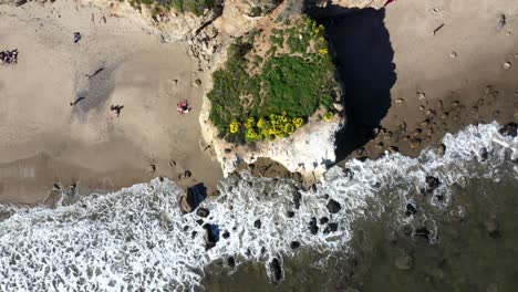 toma de drones de la playa el matador en malibu, california, que muestra el océano, las olas de agua blanca y la playa desde arriba