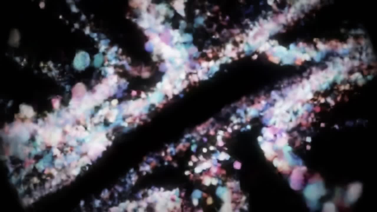 A Stunning Visual Journey Through Abstract Patterns of Light and Color, Capturing the Fluid Dynamics of Sparkling Particles Against a Dark Background