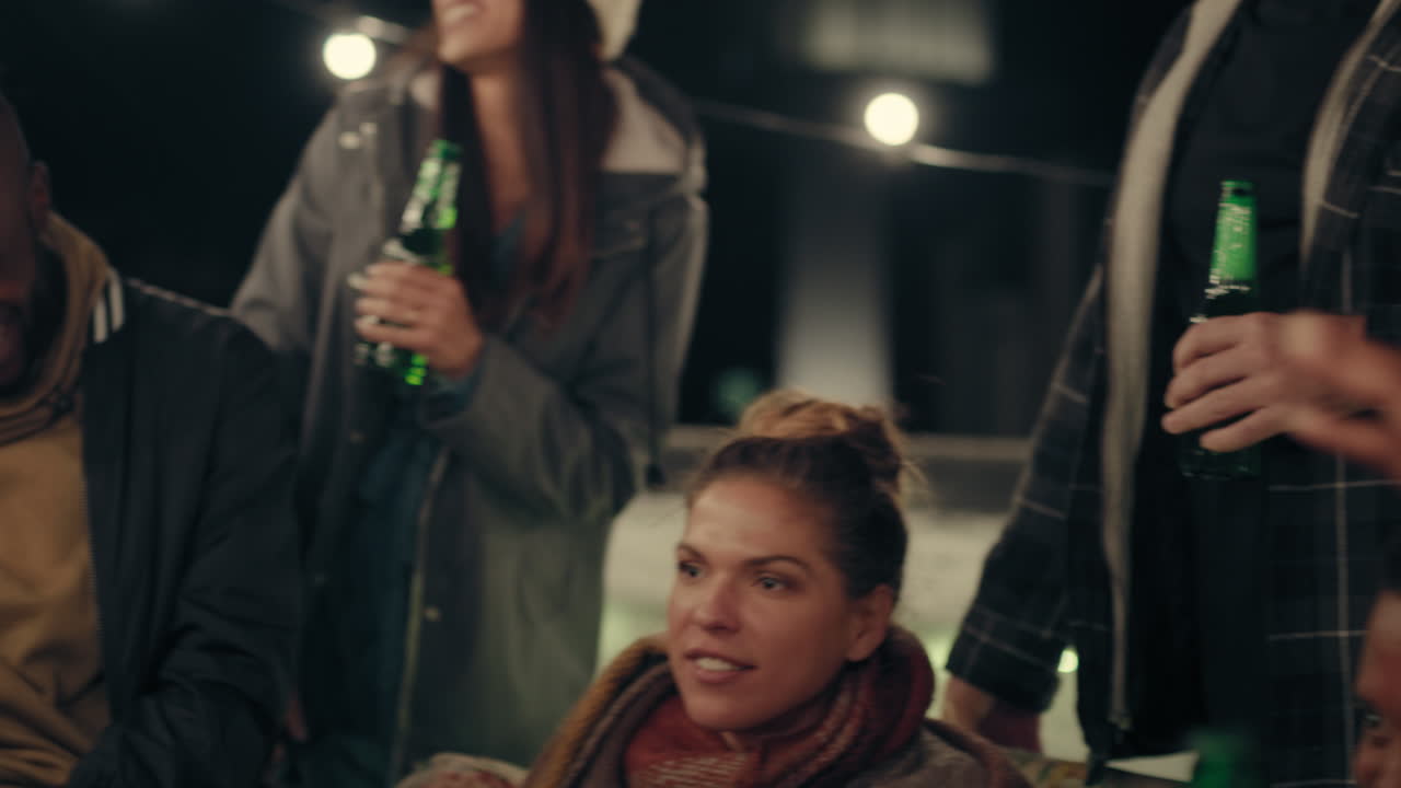 multi ethnic group of friends enjoying rooftop party celebration drinking alcohol having fun social gathering celebrating weekend of friendship at night
