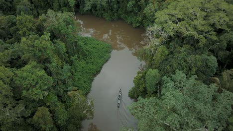 canoe boat travelling on the river through amazon rainforest in ecuador