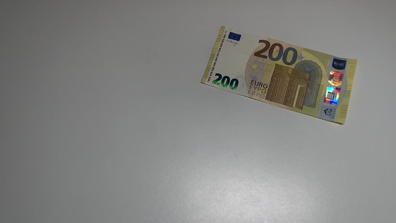 Fliegende 200-Euro-Banknote auf weißem Hintergrund in Zeitlupe