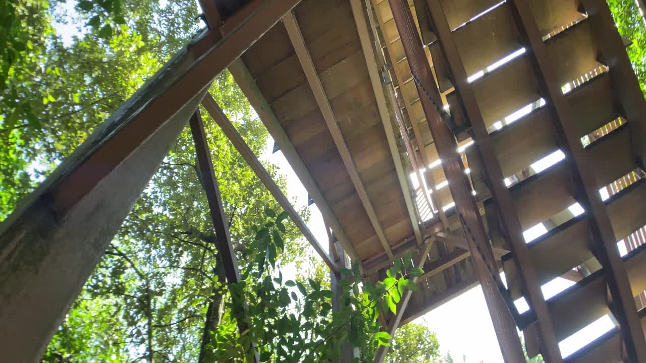 Looking up the Wooden Stairs of the Jejawi Tower in Pulau Ubin, Singapore- low angle rotating shot