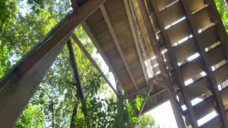 looking up the wooden stairs of the jejawi tower in pulau ubin, singapore- low angle rotating shot