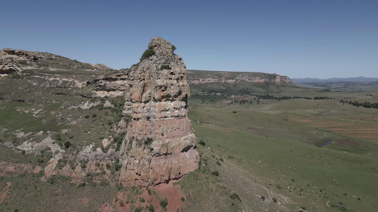 acantilado de roca prominente se eleva sobre la meseta verde de la montaña circundante