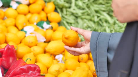 mujer comprando limones en un mercado