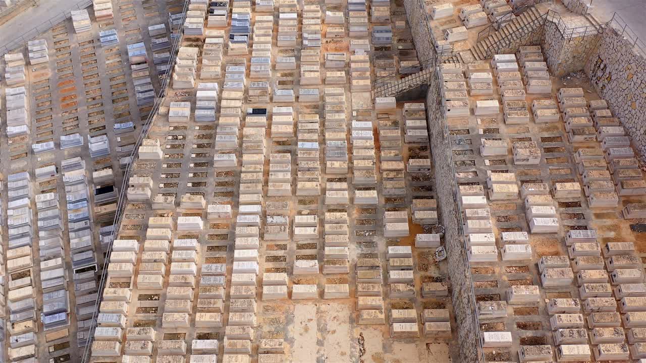 Aerial view of a vast cemetery with numerous rows of stone tombs