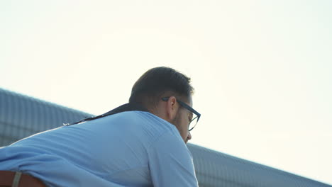 camera moving from the face of an attractive man riding a bicycle to the bottom of the wheels