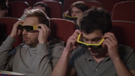 male friends wearing 3d glasses in cinema. spectators get ready watch 3d movie