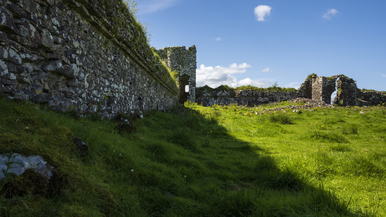 lapso de tiempo de las ruinas abandonadas del castillo en el paisaje rural de hierba de irlanda en un día soleado de verano