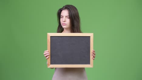 young beautiful woman nodding no while holding blackboard
