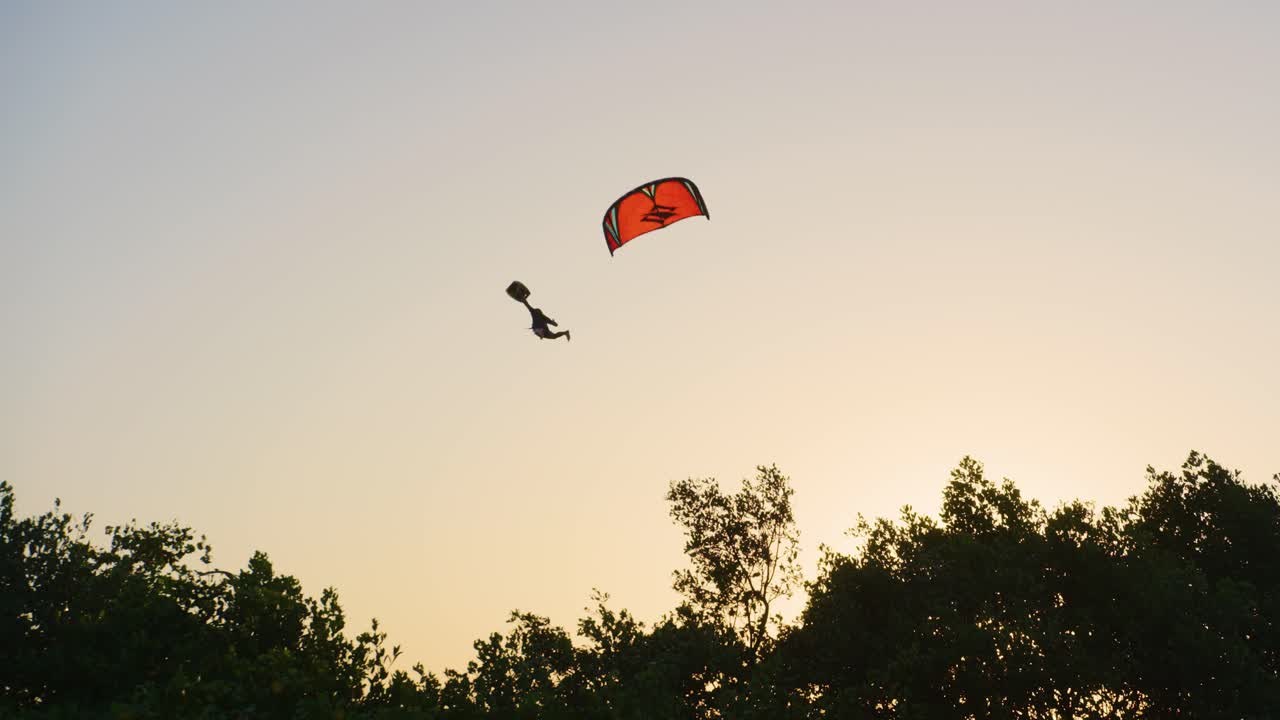 카이트서퍼가 큰 점프에서 발사할 때 서사시 공중 이동 - 노란색 일몰 하늘과 멋진 대조