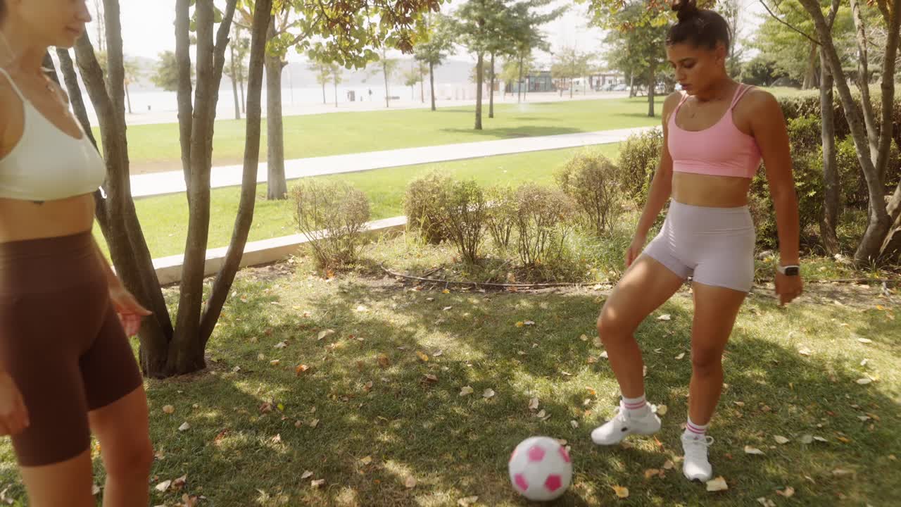 Women playing soccer in the park